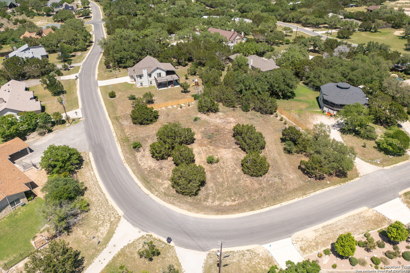 Flat .635 acre corner lot in Canyon Lake with peekaboo lake views. This rare level lot is at the top of a small hill in the Cougar Ridge subdivision.  New cedar fencing and privacy trees planted. Recent pin finding and staking. No HOA and easy restrictions. 1400 sq ft minimum house size,  Easy building/construction options with slab on grade, level lot.
