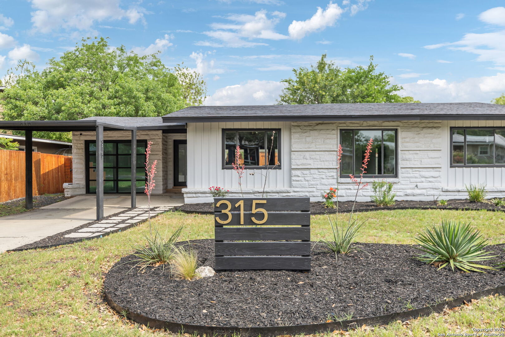 OPEN HOUSE May 10 @ 2-4pm ** Pink has never looked so elegant and approachable! Step inside this custom remodel, updated with an eye for design. From its wide-plank wood floors to its black accents and brass + acrylic hardware, you'll love every detail. Complete with four true bedrooms and three full baths, this idyllic home is ready for the magazines. An open living, dining and kitchen is illuminated by large windows and glass doors leading to the back yard. Waterfall stone counters anchor the beautiful eat-in island, with plenty of clearance for barstools. Three original bedrooms (including the primary) and two baths are together on one side of the house. With double doors to the exterior, the primary features an ensuite bath and sliding closet doors. A surprising second living room flanks the other side of the home, also housing laundry connections. Its opaque glass wall gives privacy and sunlight to this bonus room. The fourth bedroom is accessed by walking through the second living room and features its own attached bath and private exit. Enjoy the low maintenance landscaping, fully fenced back yard, and covered carport parking. Located blocks from Alamo Heights Junior School and Woodridge Elementary, experience this stylish home in Northridge AHISD!