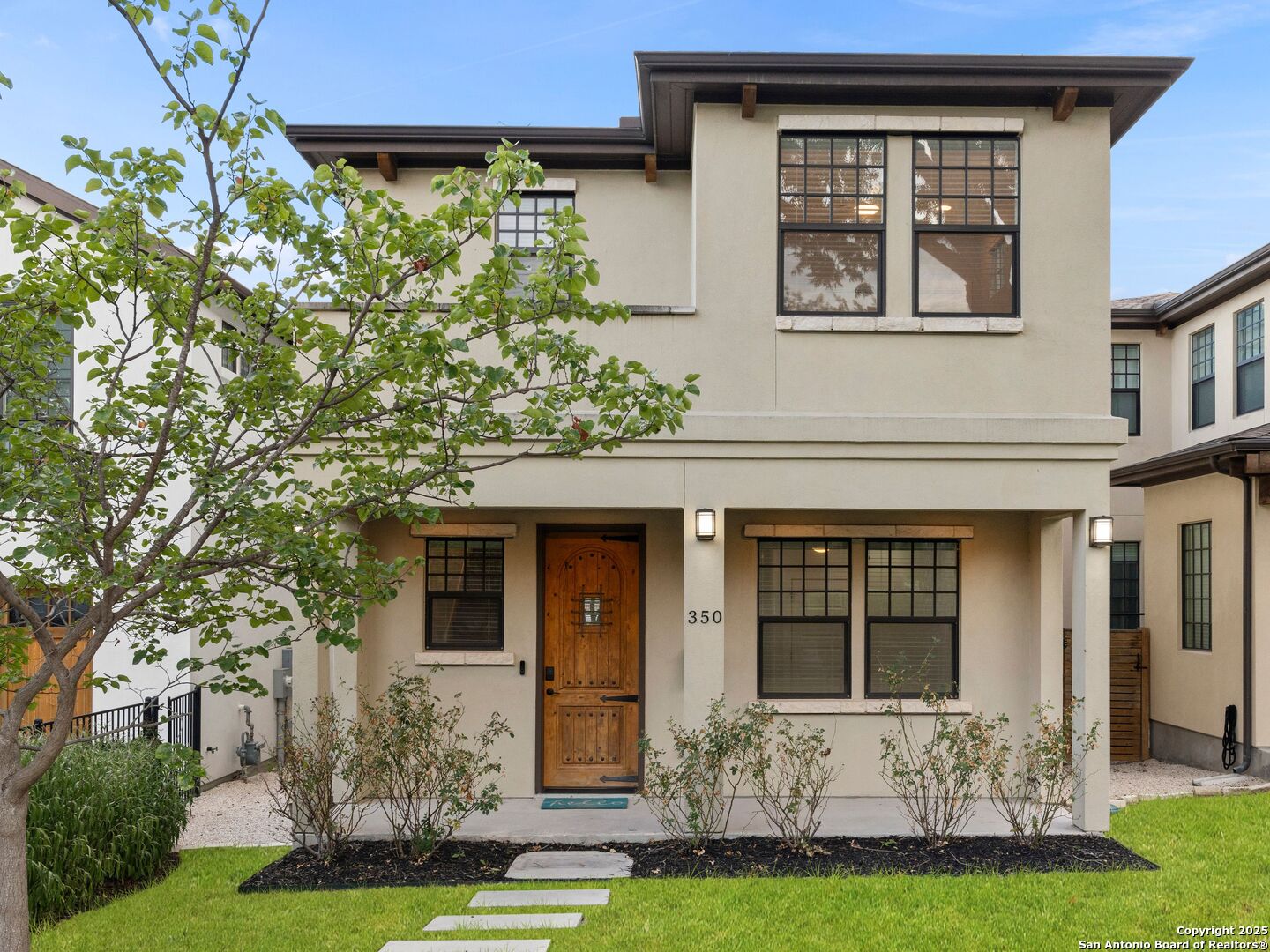 Nestled in the highly sought-after Olmos Park neighborhood, this stylish garden home offers an open-concept layout filled with natural light, soaring ceilings, and designer finishes, creating an inviting space that's both elegant and functional. At the heart of the home, the kitchen impresses with an oversized island, custom cabinetry, stainless steel appliances, white quartzite counters, and a walk-in pantry. Perfect for entertaining, the kitchen flows seamlessly into the dining and living areas. A comfortable secondary bedroom with a full bath is conveniently located on the main level, offering flexibility for guests or a home office. Upstairs, you'll find the spacious primary suite, designed as a private retreat with a spa-like bathroom featuring a double vanity, walk-in shower, and generous walk-in closet. Two additional well-sized bedrooms and another full bathroom provide ample space for family or guests, while the conveniently located utility room adds everyday convenience. The thoughtful layout ensures comfort, privacy, and functionality for all. The low-maintenance backyard is designed for relaxation, featuring a covered patio. A rear-entry garage, accessible from the alley, ensures both convenience and privacy. This property offers the perfect balance of style, comfort, and location, just minutes from restaurants, shopping, and the charm of Olmos Park living.