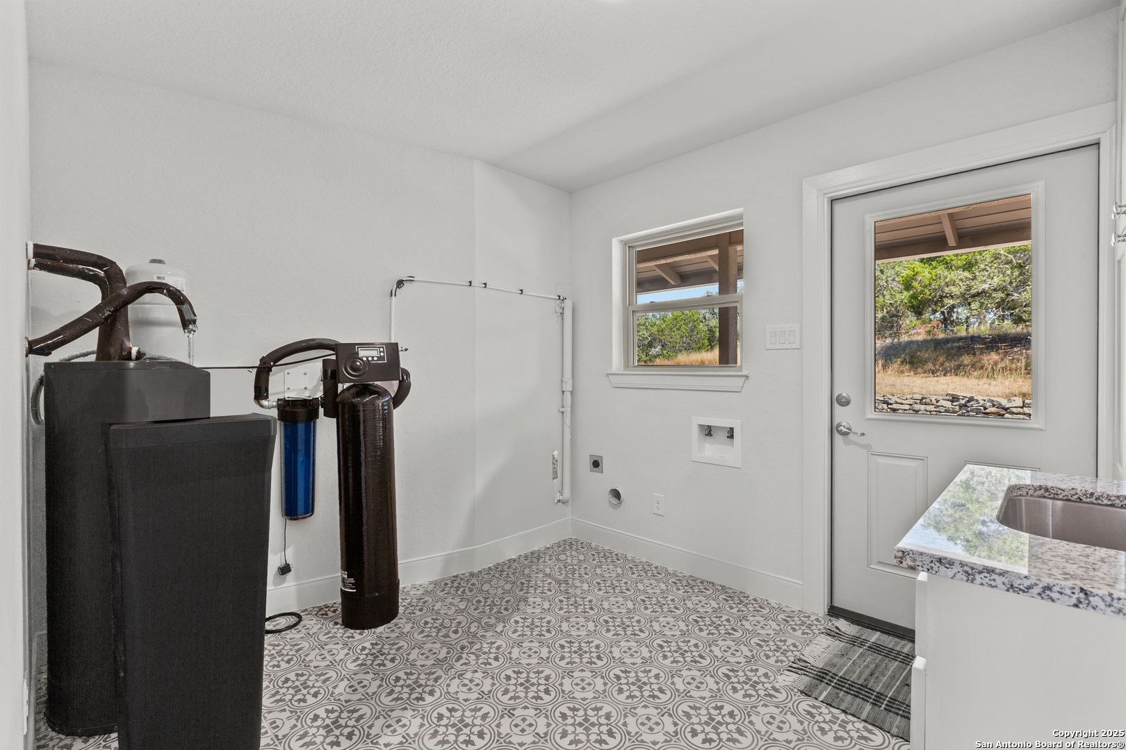 Utility room with a sink, storage, water softener.