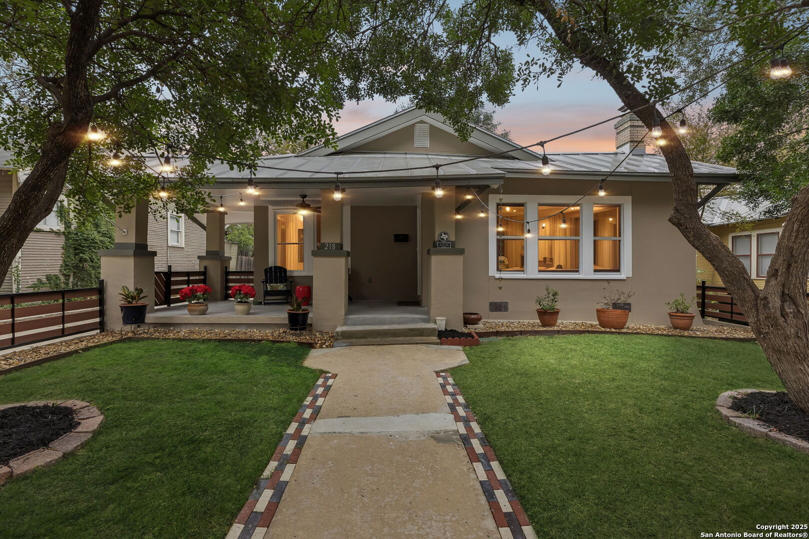 Expertly restored and beautifully finished, this Mahncke Park classic home and guest house blend original charm with modern sophistication. Home and guest house together equal nearly 2000 sqft.  Dark wood floors, high ceilings, and an open-concept layout create a dramatic yet welcoming living space. The updated kitchen showcases rich granite countertops, stainless steel appliances, and an effortless connection to the dining and living areas - ideal for daily living and entertaining. Abundant natural light streams through well-placed windows, highlighting the home's thoughtful details, including glass door knobs, polished hardware, and tastefully updated bathrooms that complement the home's timeless character.  Outdoors, the spacious screened porch overlooks mature landscaping, framed by a uniquely crafted perimeter fence that enhances curb appeal and privacy.  A few steps from the patio is a fully finished, guest house constructed in 2022. It has two rooms and a full bath, perfect for guests, multigenerational living, or a dedicated office suite. A separate laundry building and additional storage structure provide exceptional flexibility and functionality.  Located just minutes from the Botanical Garden, the Zoo, the Pearl, and major cultural destinations, this turnkey property offers a rare opportunity to enjoy historic living with modern conveniences in one of San Antonio's most beloved neighborhoods.