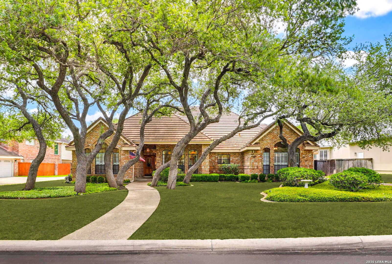 OPEN HOUSE SUNDAY 5/17, 1:00 to 4:00. Welcome to this beautiful sprawling one-story home located in the prestigious Fairways of Sonterra. Nestled among perfectly maintained grounds and majestic oak trees, this timeless residence offers classic charm, exceptional privacy, and flexible living spaces throughout. This spacious home offers 4 bedrooms and 3.5 baths in the main house, plus a private 376 sq. ft. guest suite with full bath above the detached 2-car garage, connected by a convenient drive-through portico-making this a true 5 bedroom, 4.5 bath property.  Inside, you'll find soaring ceilings, abundant natural light, multiple French doors, and a covered patio that spans the length of the home for seamless indoor-outdoor living. The split floor plan provides privacy, with a separate bedroom and bath ideal for a study.  The primary suite features a sitting area, fireplace, patio access, whirlpool tub, oversized walk-in closet, and dual vanities. An automatic electric gate adds extra privacy to the side and backyard. This exceptional home is a must-see.