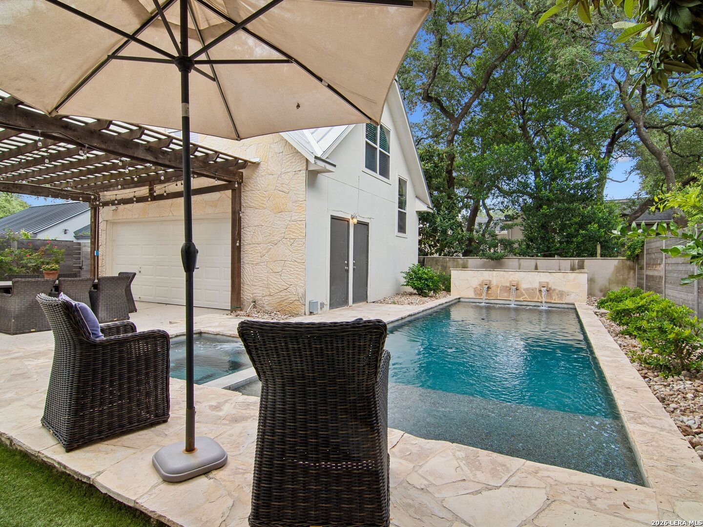 This beautiful 4-bedroom, 4-bathroom home perfectly captures the charm and character that Alamo Heights is known for. Nestled in Alamo Heights and surrounded by mature trees and lush landscaping, the property offers exceptional privacy and timeless appeal. As you step through the front door, a warm and inviting atmosphere immediately welcomes you. The formal living room, complete with a fireplace, provides the perfect setting for entertaining and large gatherings. The home flows seamlessly into a casual dining area and an updated chef's kitchen featuring a built-in refrigerator, dishwasher, double ovens, gas cooktop, an oversized island, and a breakfast bar. Just beyond the kitchen, a spacious second family room with French doors opens effortlessly to the expansive covered back porch, creating ideal indoor-outdoor living. On the opposite side of the home, a private guest suite with a full bath offers comfort and flexibility for visitors. The oversized primary suite is filled with natural light and serves as a relaxing retreat. The beautifully updated primary bathroom features a custom walk-in closet, dual vanities, built-in storage, and a large walk-in shower. Upstairs, you'll find two additional bedrooms, two full bathrooms, and a generous game room - all continuing the home's signature charm and thoughtful design. The backyard is truly the showpiece of the property. Designed for entertainment, the oversized patio overlooks a stunning Keith Zars pool and beautifully landscaped surroundings, creating a private outdoor oasis. Adding even more versatility, the guest suite above the garage offers approximately 576 square feet of additional living space. It includes a living room/bedroom, and full bathroom - ideal for guests, a private office, or a homeschool/study area. The oversized two-car garage provides abundant storage, while the property as a whole offers the perfect blend of luxury, comfort, privacy, and functionality.